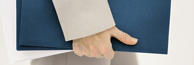 vbw informiert über Veränderungen im Wirtschaftsrecht Weibliche Hand hält dunkelblaue Akte
